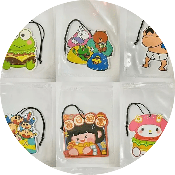 A group of six different cartoon characters hanging from the side of a bag.